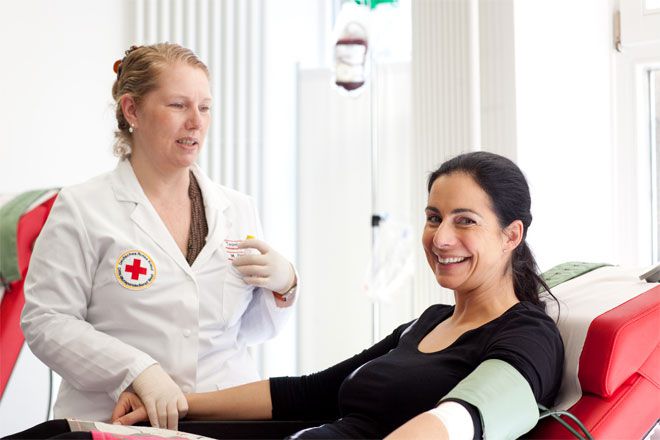 Foto: Eine Ausbilderin führt den Teilnehmern die Herzdruckmassage an einem Dummy vor.